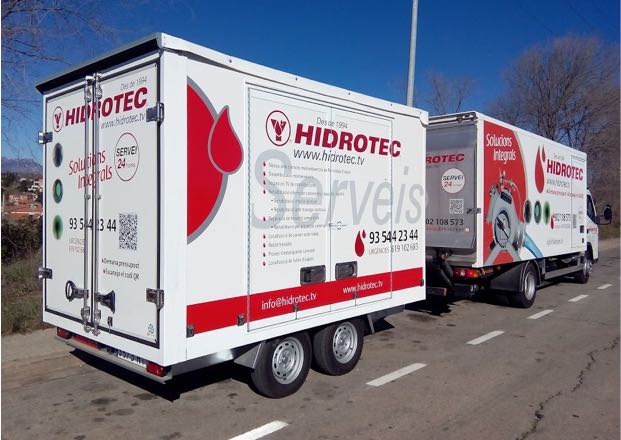 Furgón de Hidrotec. El camión es blanco y con las letras y el logo rojo.